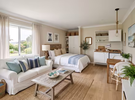 AI-generated coastal studio apartment interior design: a white slipcovered sofa with sea-glass blue and striped cushions