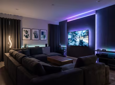 AI-generated gamer den living room interior design: an ambient RGB-lit entertainment lounge