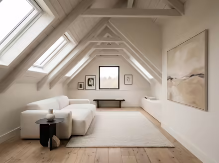 AI-generated minimalist attic interior design: an almost empty room done perfectly: one exceptional low sofa in off-white