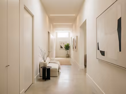 AI-generated minimalist hallway interior design: an almost empty room done perfectly: one exceptional low sofa in off-white